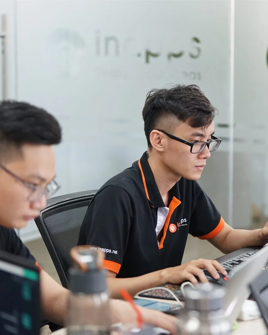 Two InApps engineers at their laptops in the Ho Chi Minh City office